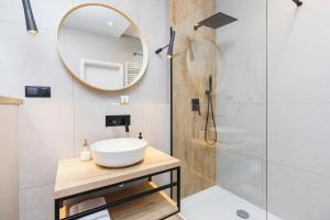a bathroom with a sink and a mirror at Apartament 3d GO by Renters in Krakow