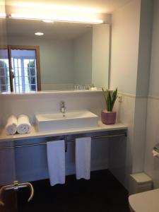 een badkamer met een wastafel en een spiegel bij Villa Reymar - diseño y vistas al mar in Tossa de Mar