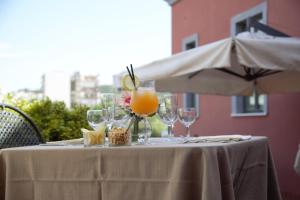 a table with glasses of orange juice and snacks on it at Hotel Nuvò in Naples