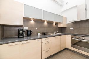 a kitchen with white cabinets and stainless steel appliances at Native Apartments Czysta 5 in Kraków