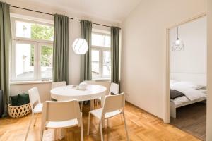a dining room with a table and chairs and a bed at Native Apartments Czysta 5 in Kraków