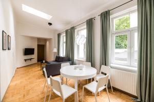 a living room with a table and chairs and a couch at Native Apartments Czysta 5 in Kraków +18 photos