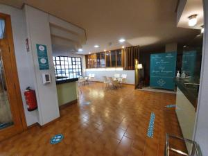 una habitación vacía con mesas y sillas en un edificio en Hotel Alda Boiro, en Boiro