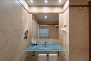 a bathroom with a sink and a mirror at Hotel MS Maestranza Málaga in Málaga