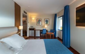 a hotel room with a bed and a table and chairs at Hotel MS Maestranza Málaga in Málaga