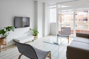 a living room with a couch and chairs and a tv at Apartamento Isaga Lecera in Zarautz