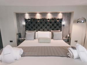 a bedroom with a large bed with a large headboard at The Grand Hotel in Swansea