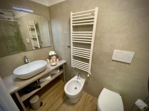 bagno con lavandino, servizi igienici e specchio di Five Flowers - Guest House a Trieste