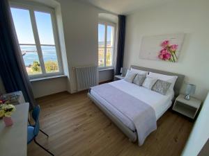 a bedroom with a bed and two windows at Five Flowers Guest House - self check-in in Trieste