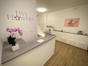 a shop with a counter with flowers on the wall at Five Flowers Guest House - self check-in in Trieste