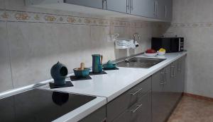 a kitchen with a sink and some vases on the counter at Casa Arte in San José de Caideros