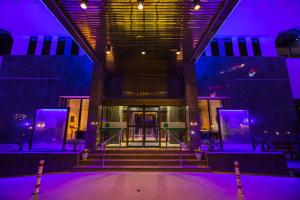 un escenario con luces púrpuras frente a un edificio en Hotel Muscat Holiday en Mascate