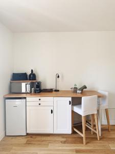 uma cozinha com uma mesa de madeira e um frigorífico branco em L'anne xe, studio indépendant em Valeuil