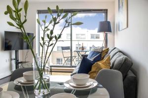 uma sala de estar com uma mesa e um sofá em Contractor Apartment & Private Parking & Central Stevenage em Stevenage