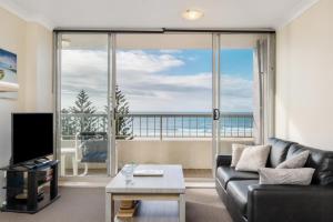 a living room with a couch and a large window at Eden Tower Apartments in Gold Coast