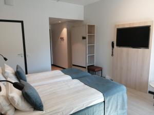 a bedroom with a bed and a flat screen tv at Pilot Airport Hotel in Vantaa