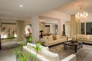 a living room with white furniture and a chandelier at Maison Dedine- SmallLuxuryHotels -Adults Only in Sidi Bou Saïd