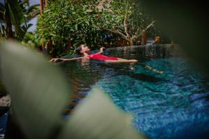 a young girl laying in a swimming pool at Amathus Beach Hotel Limassol in Limassol