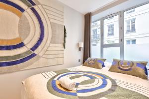 1 dormitorio con 2 camas y una gran pintura en la pared en 121 - Urban Gorgeous Flat in Montorgueil en París