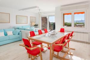 een eetkamer met een tafel en rode stoelen bij Grand Dúplex Portosín by Upper Luxury Housing in Portosin