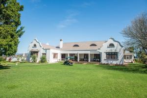 a large white house with a large yard at Excelsior Manor Guesthouse in Ashton