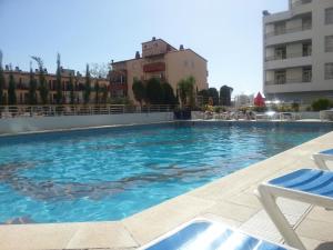 ein Schwimmbad mit blauem Wasser in einem Gebäude in der Unterkunft Xon's Platja HA in Empuriabrava