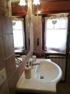 uma casa de banho com um lavatório e um dispensador de sabão em A casa di Iole em Fiumicino