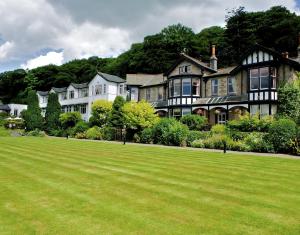 a large house with a large green lawn at Castle Green Hotel In Kendal, BW Premier Collection in Kendal