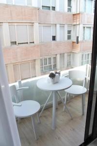 a white table and chairs on a balcony with a window at VV Loft Canteras Gran Playa "by henrypole home" in Las Palmas de Gran Canaria