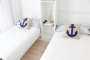 2 Betten in einem Zimmer mit weißen Wänden in der Unterkunft VV Loft Canteras Gran Playa "by henrypole home" in Las Palmas de Gran Canaria