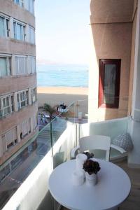 einen Tisch und Stühle auf einem Balkon mit Blick auf den Strand in der Unterkunft VV Loft Canteras Gran Playa "by henrypole home" in Las Palmas de Gran Canaria
