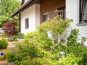 ein Schmetterlingsbusch vor einem Haus in der Unterkunft Ennerla Hof in Pottenstein