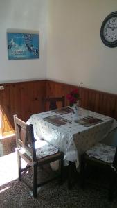 a table and two chairs in a room with a clock at L'arbrissel in Fontevraud-l'Abbaye