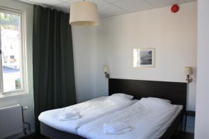 una camera da letto con un letto con lenzuola bianche e una finestra di Grännagården a Gränna