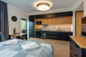 a bedroom with a bed and a kitchen at TartuKodu Riia 20B-13 in Tartu