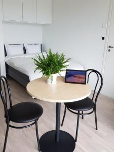 uma mesa com duas cadeiras e um portátil em New studio in West-Pasila em Helsinque