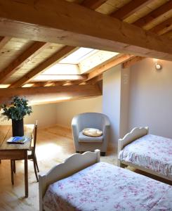 a attic room with a bed and a chair at Gite du Carbounet et la Grange de Lou in Siguer