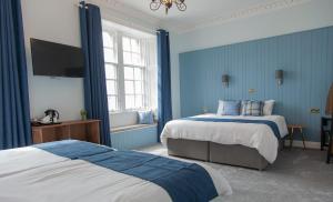 a bedroom with a bed, desk, and window at Coorie in Dunfermline