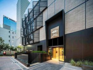 首尔Mercure Ambassador Seoul Hongdae的侧面有标志的建筑物