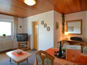 ein Wohnzimmer mit einem Tisch und einem TV in der Unterkunft Serene Apartment in Meschede with Balcony in Grevenstein