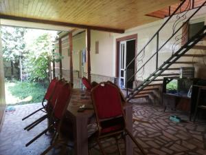 a dining room with a table and chairs and a staircase at Casa BUCUR in Târgu Ocna