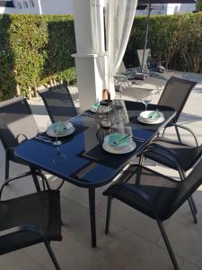 a blue table with chairs and plates on it at Villa mit privatem Pool, zentrumsnah in Roldán