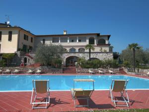 ソイアーノ・デル・ラーゴにあるComfortable holiday home in Soiano del lago with lakeviewのスイミングプールの前に椅子2脚とテーブル1台