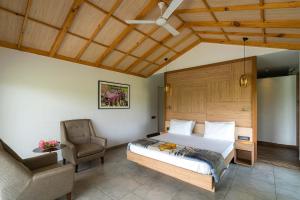 um quarto com uma cama, uma cadeira e um tecto em Baag E Fursat - Luxurious 10BR Villa with infinity swimming pool em Kūrāli