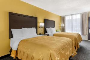 Quality Inn Verona - Staunton North في ستونتون: سريرين في غرفة الفندق بجدران صفراء