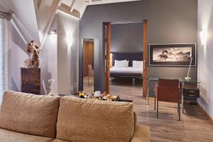 a living room with a couch and a bedroom at Hotel Silken Indautxu in Bilbao