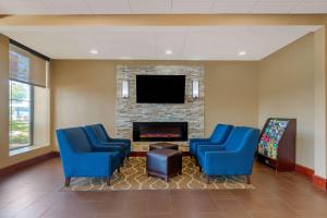 uma sala de espera com duas cadeiras azuis e uma lareira em Comfort Inn & Suites Macon West em Macon