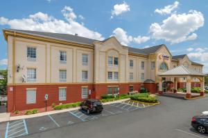 a hotel with a car parked in a parking lot at Comfort Suites Newark - Harrison in Newark