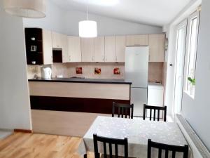 a kitchen with a table and chairs in a room at Apartament nad Jeziorem Sławskim in Radzyń +9 photos