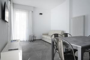 a living room with a table and chairs and a couch at Du Lac Aparments in Desenzano del Garda